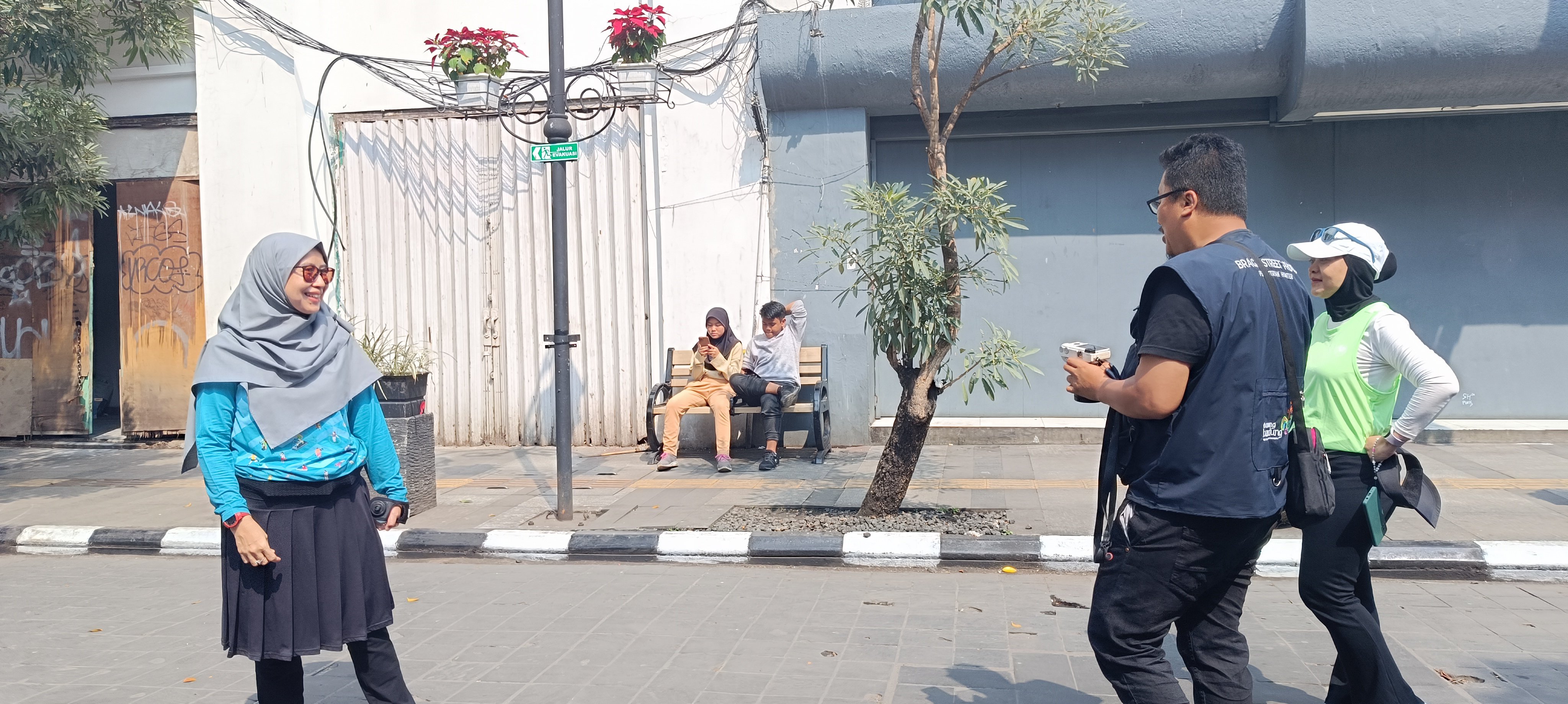 Fotografer Jalanan di Braga Beken sedang mengarahkan gaya pengunjung yang ingin difoto